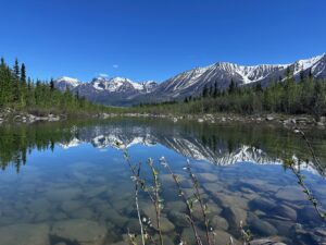 A crystal clear lake reflecting the snnow-capped mountains of Wrangell-St Ellis.